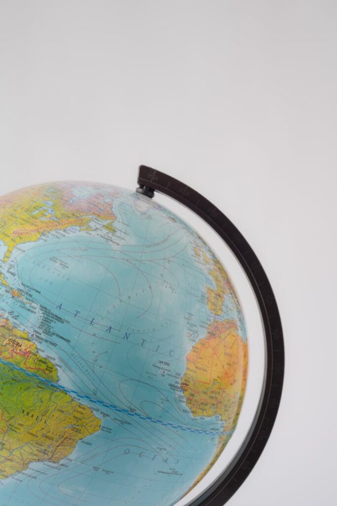 pexels photo 7634769 Minimalist close-up of a globe's meridian and continents on white background.